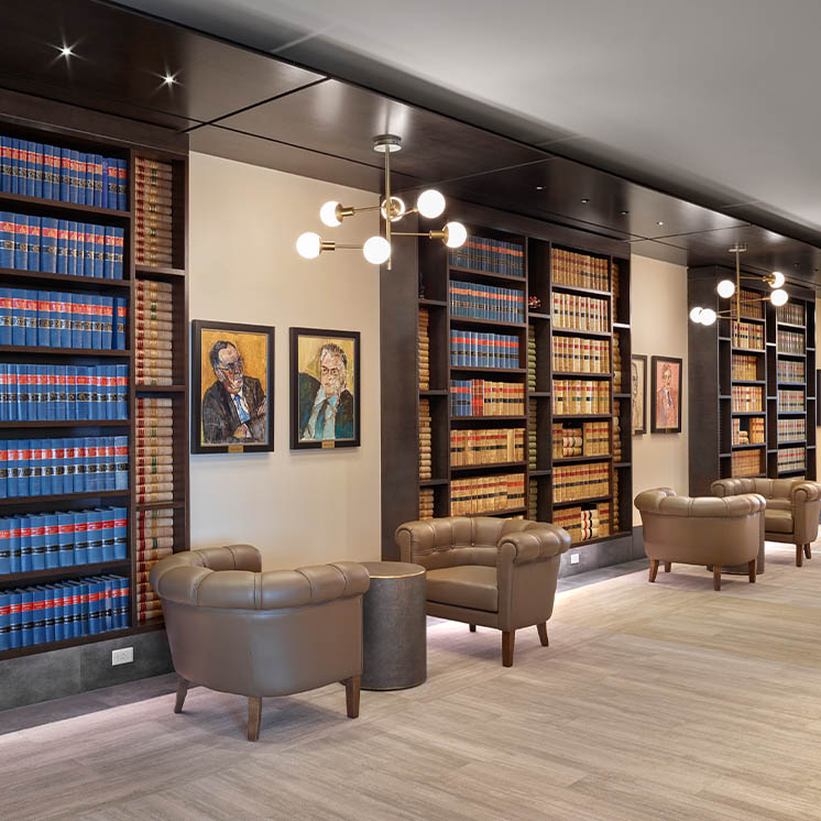 Shared lounge space with comfy leather seats and tall bookshelves Shared lounge space with comfy leather seats and tall bookshelves